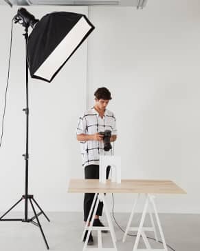 Doorstep Studio's portable photo setup - DSLR camera, softbox lighting, and neutral backdrop arranged inside a JVC home in Dubai