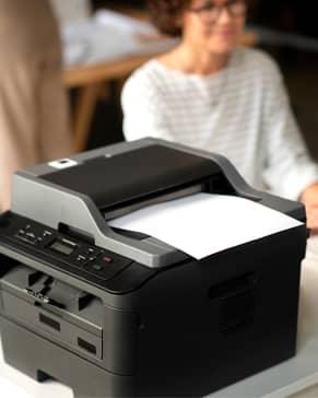 Freshly printed visa photographs on glossy photo stock, handed to a customer the same visit